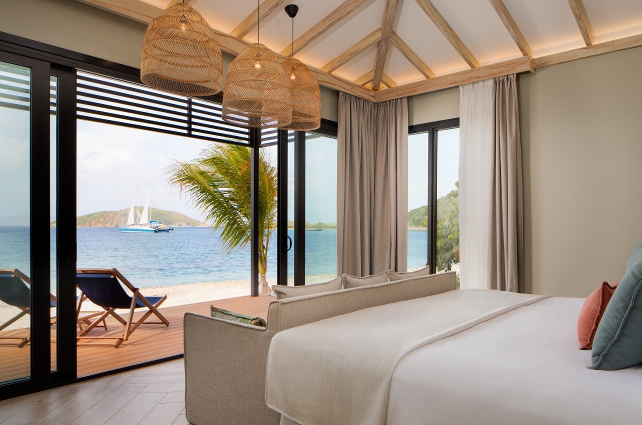 Interior of a bedroom with a beachfront view at the Peter Island Resort