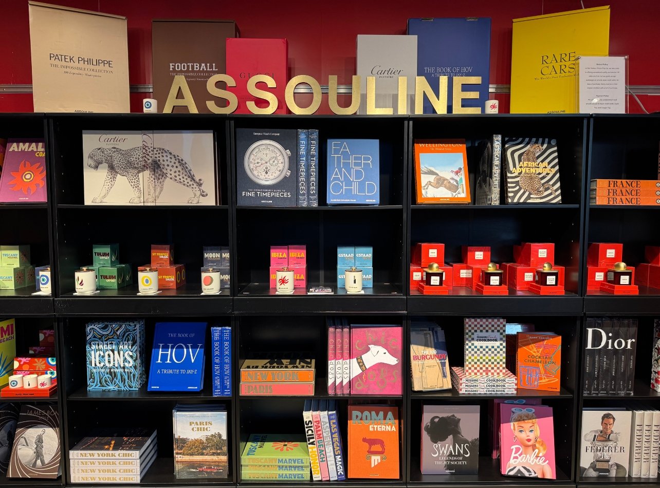 A stack of books on display for the Assouline x Impossible collection at the Bal Harbour Shops Access pop-up event