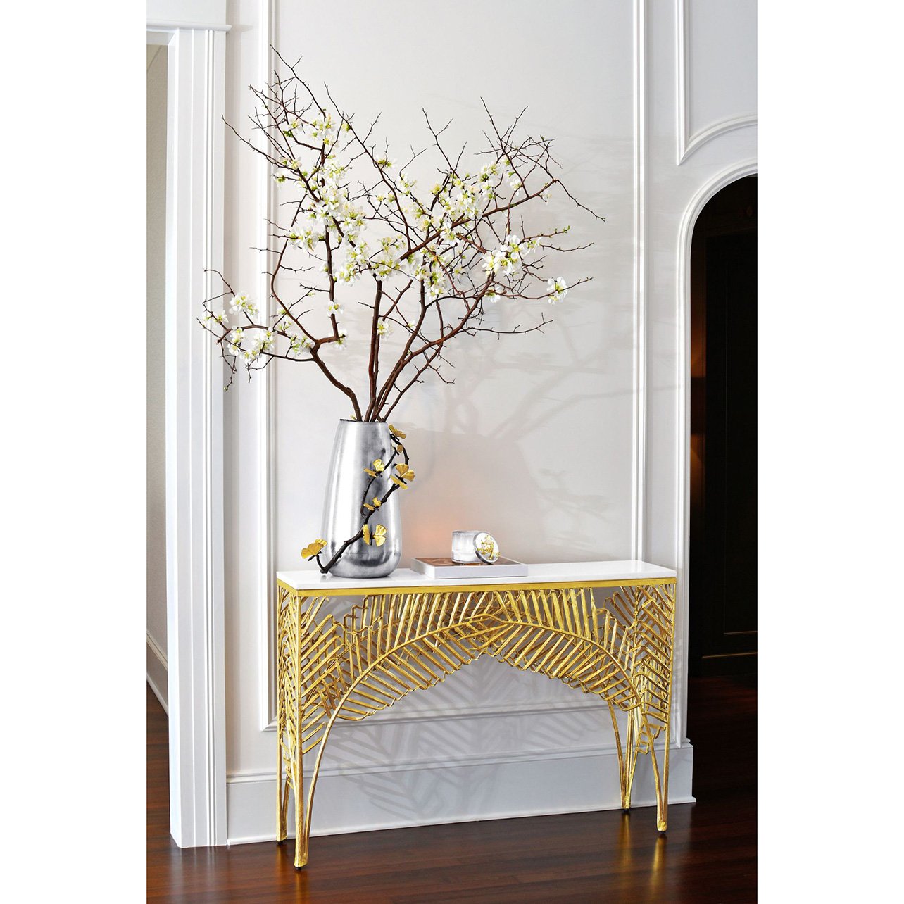 A gold palm console table with a butterfly ginko vase designed by Michael Aram
