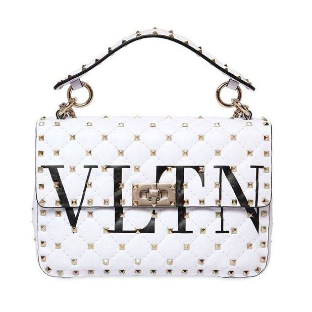 If you need a little color break, then Valentino has made the go-to bag for you with their white VLTN top handle bag.