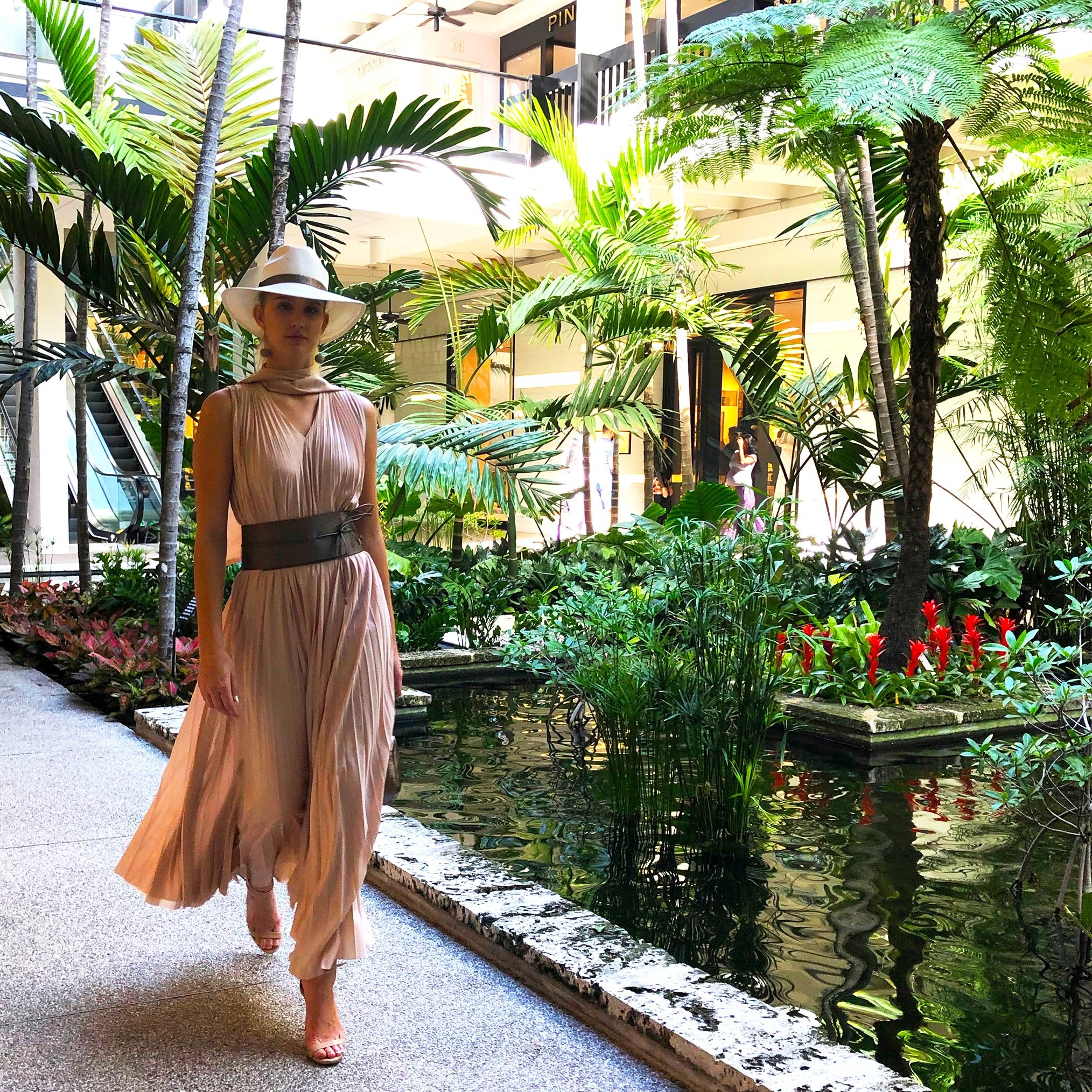 Model strolling by the signature Bal Harbour koi ponds wearing a Fabiana Filippi pleated nude chiffon dress