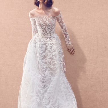 Long sleeve allover floral lace embroidered lace gown with tulle overskirt and featuring organza appliqués attached on to a base of ari embroidery threadwork for a 3-D effect, totaling 80 hours of work to complete.