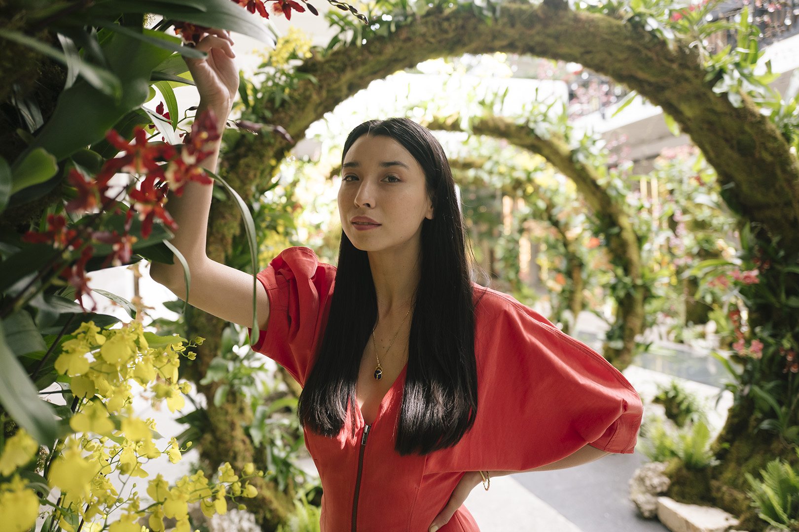 Lily Kwong highlights one of the hundreds of orchids that make up the 'Moongates' landscape art installation. Photograph by Gesi Schilling