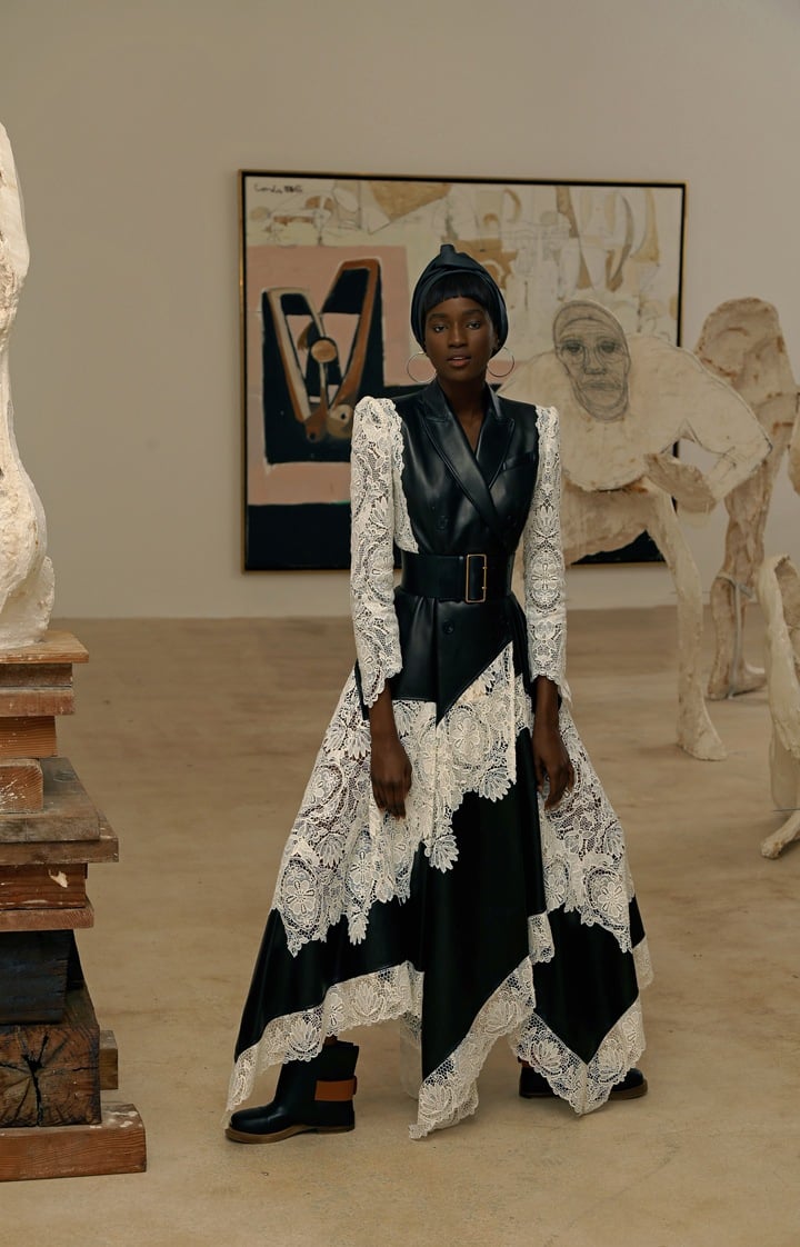 Alexander McQueen dress, boots with buckles and oversized waist belt. Lana silver hoops, available at Saks Fifth Avenue. Artwork by Thomas Houseago (foreground) and George Condo.