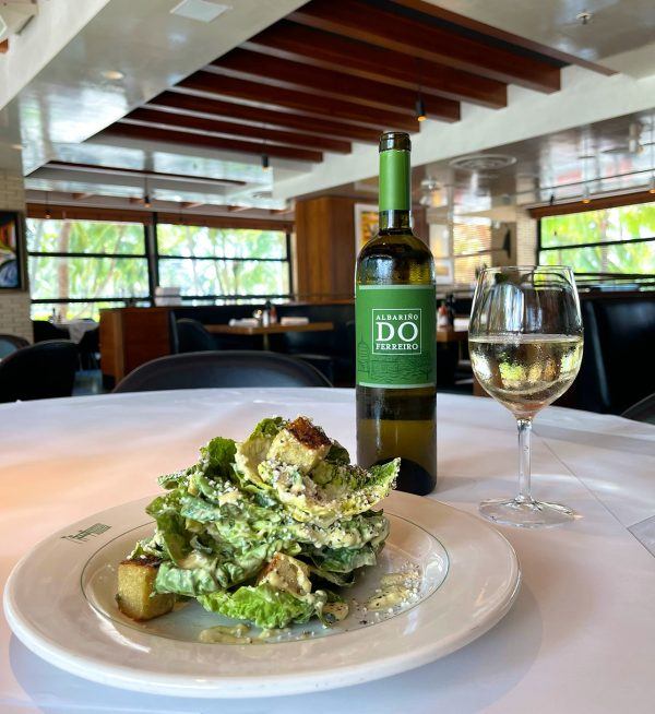 Hillstone Caesar salad paired with a glass of natural white wine