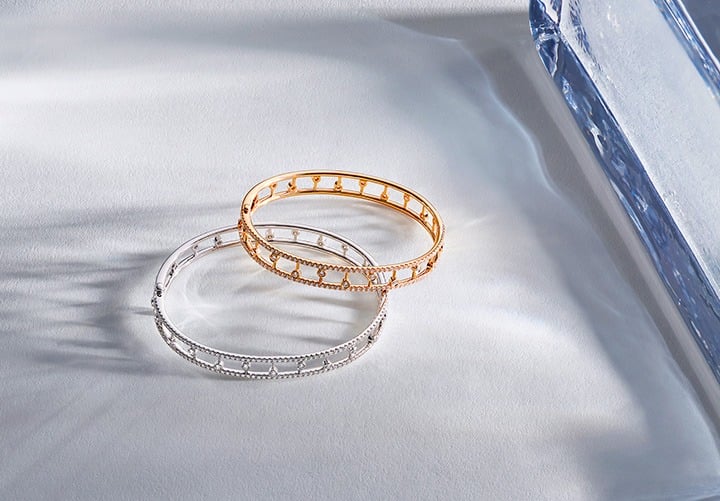Dewdrop Bangle featured in White Gold and Rose Gold from the De Beers Dewdrop Collection