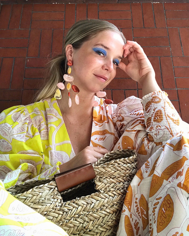 Chloe King wearing a Deloreta dress, cult gaia earrings and Officine del Poggio bag.