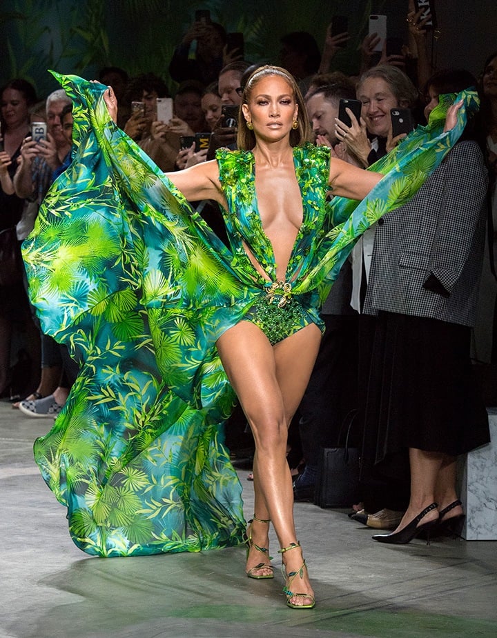 A 50-year-old Jennifer Lopez stole the spotlight at the Versace Spring 2020 show wearing a reprisal of the plunging palm frond frock she wore in 2000.