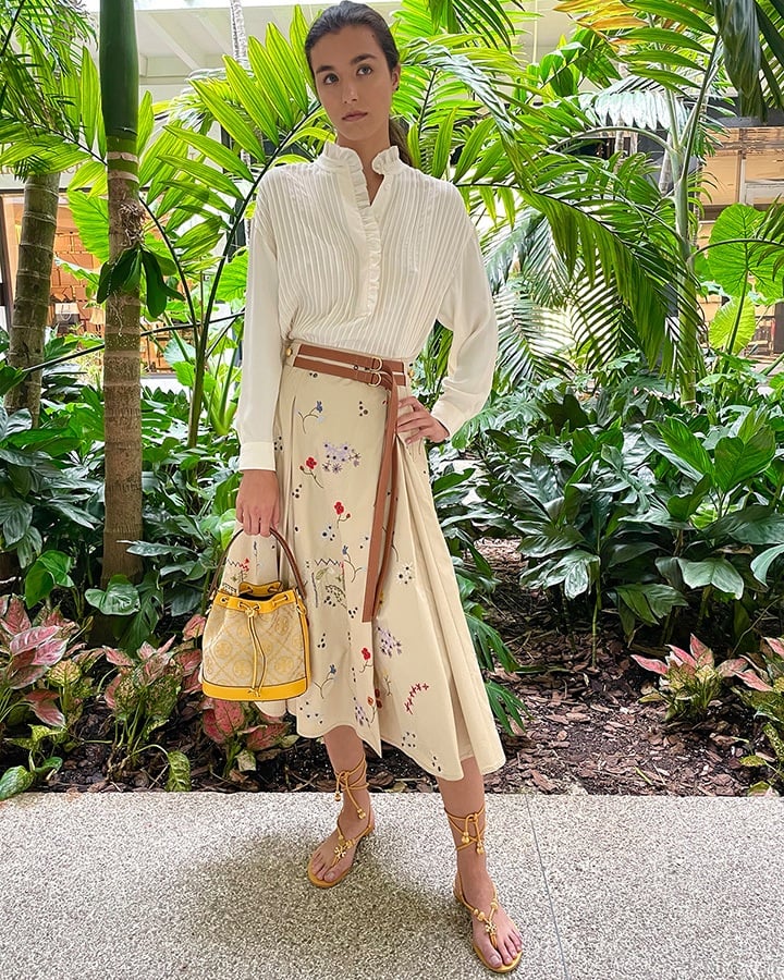 Tory Burch T monogram jacquard bucket bag, ruffle-front blouse, embroidered pleated skirt and capri flat lace-up sandal from the SS21 collection.