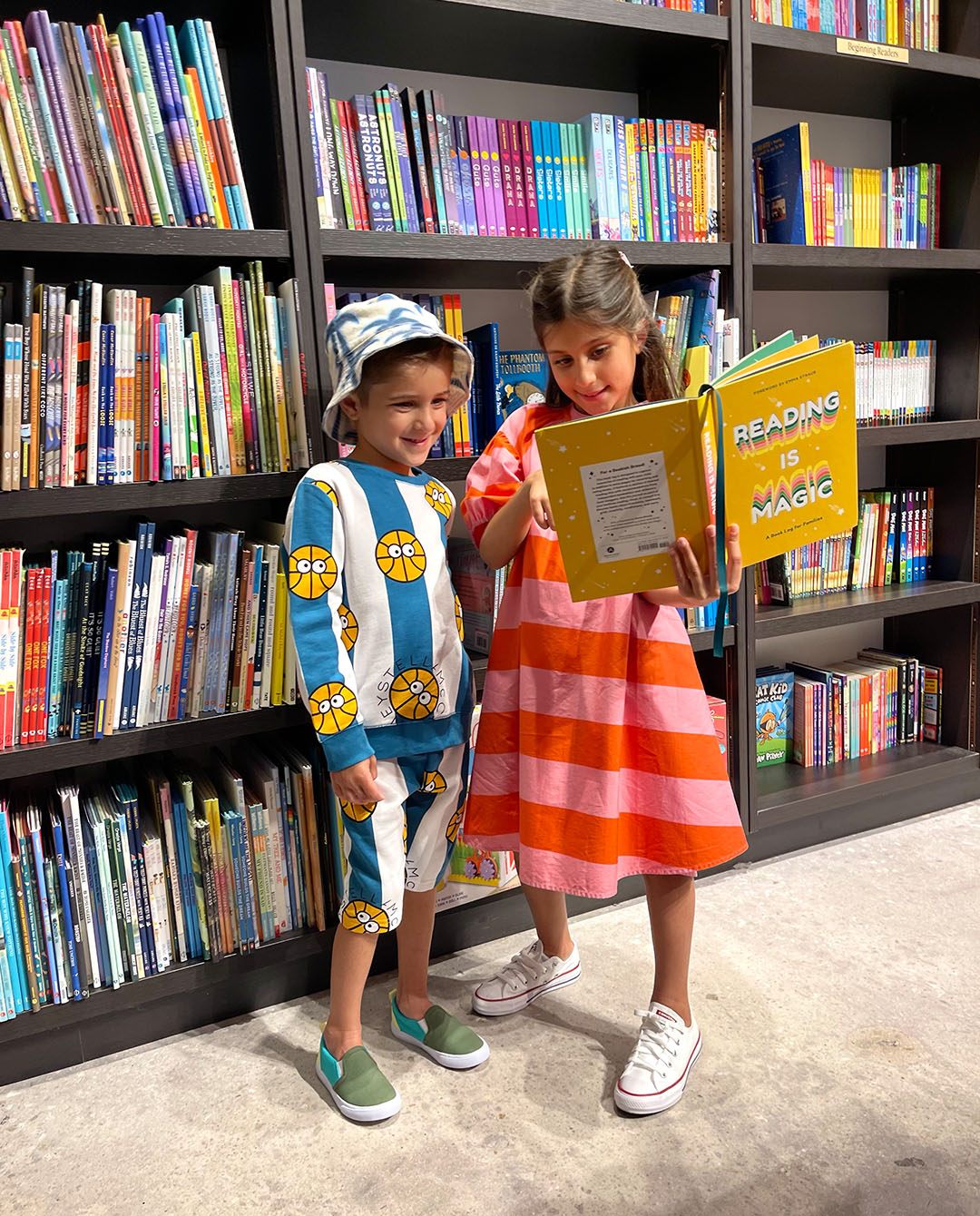 Pictured at Books & Books, Stella McCartney basketball-print sweatshirt, shorts Palm-print denim hat; Stella McCartney striped cotton dress.