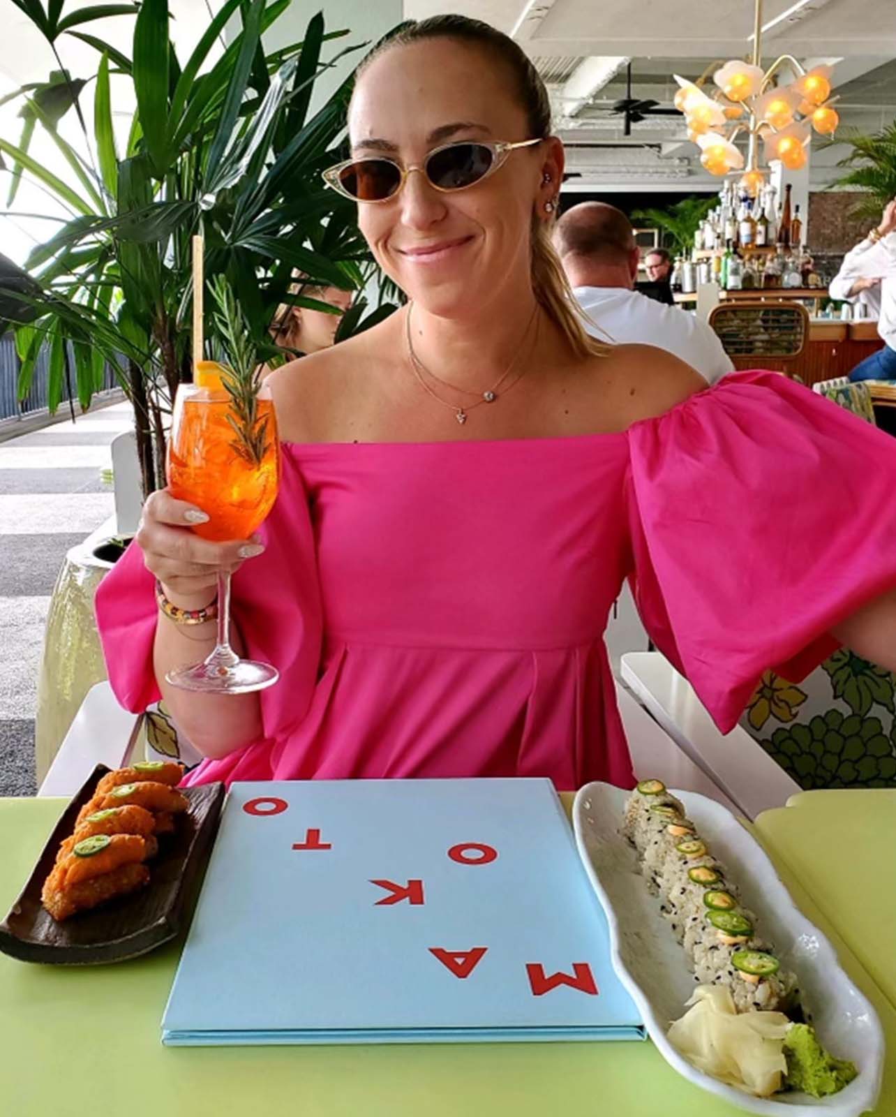 Woman smiles with a variety of sushi plates