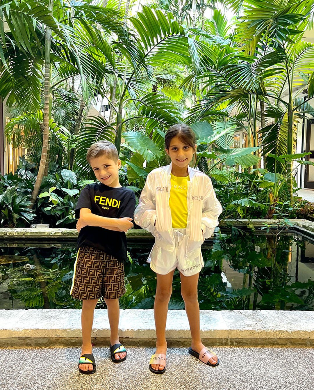 Givenchy zip up jacket and matching shorts, yellow t-shirt, and logo-print slides; Fendi t-shirt, logo shorts and signature eye slides available at Couture Kids.