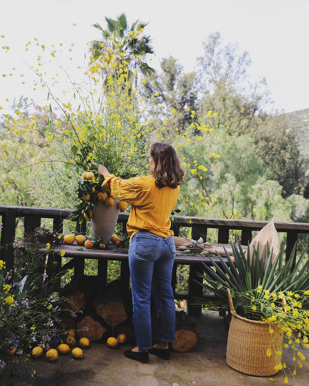 Moreno-Bunge at work on an arrangement of foraged wild mustard branches mixed with local citrus