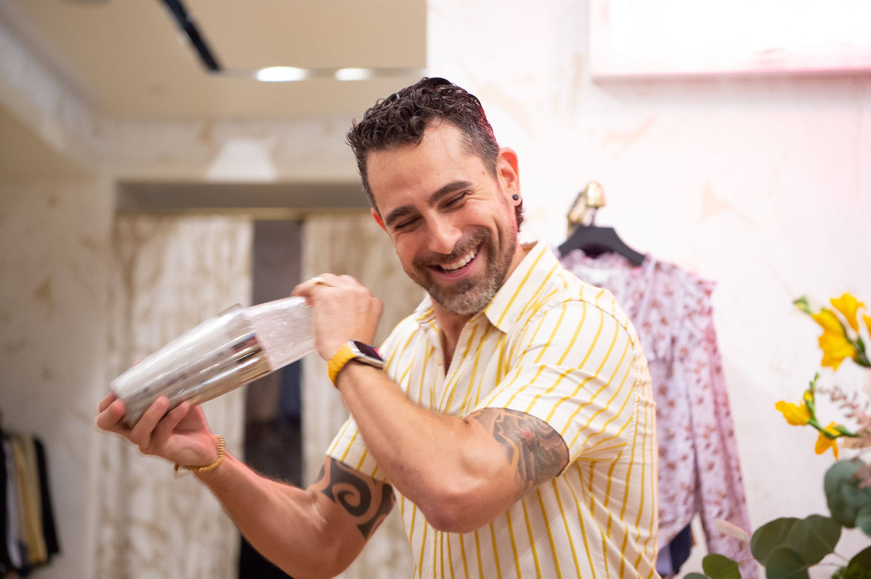 Man shaking a cocktail shaker while smiling