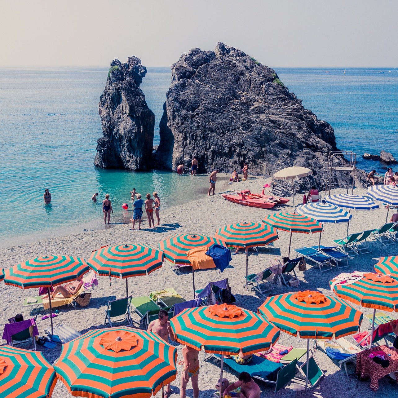 Photo of the Monterosso coast lined with mutli-colored umbrellas