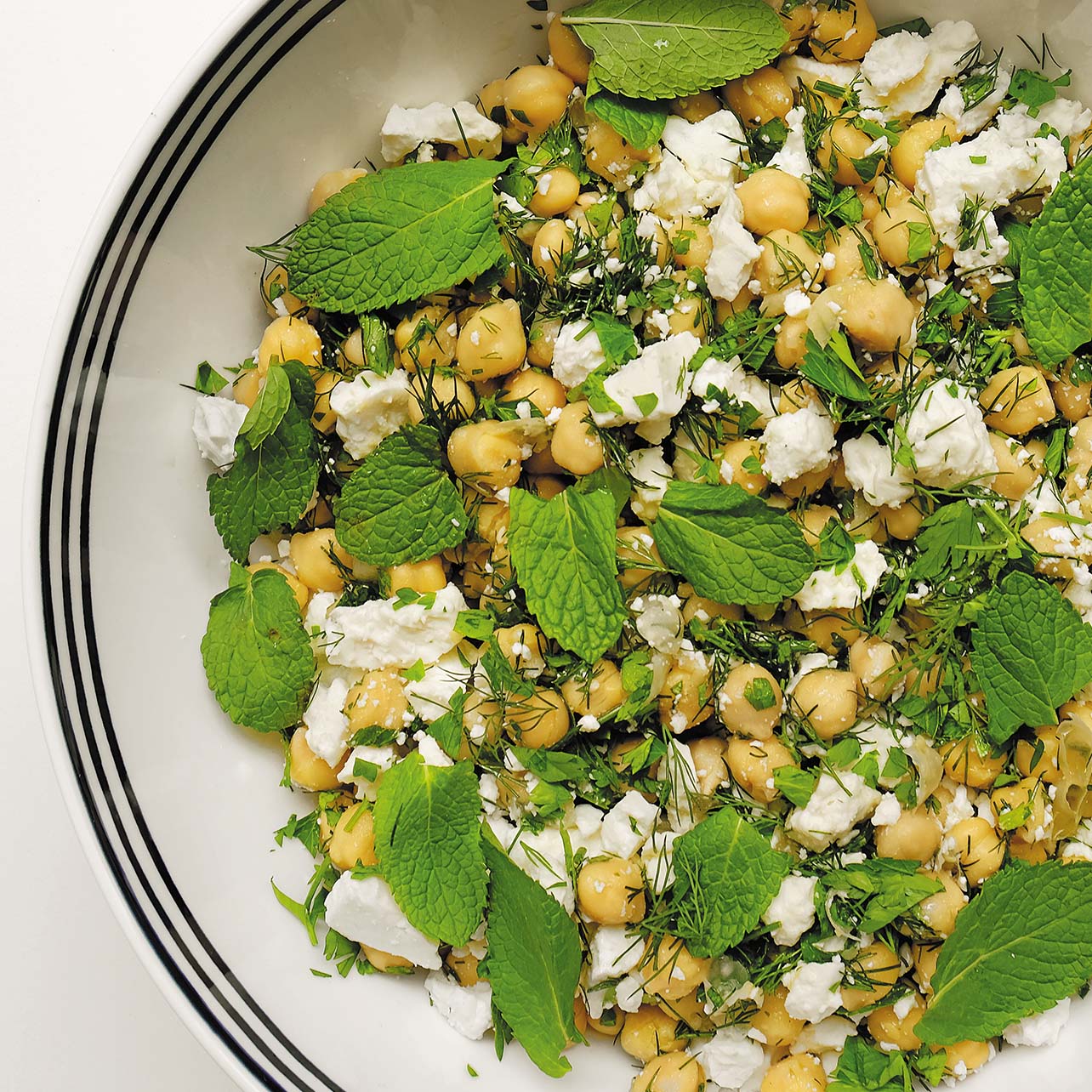Aerial photo of a chickpea salad with feta cheese and an herb garnish