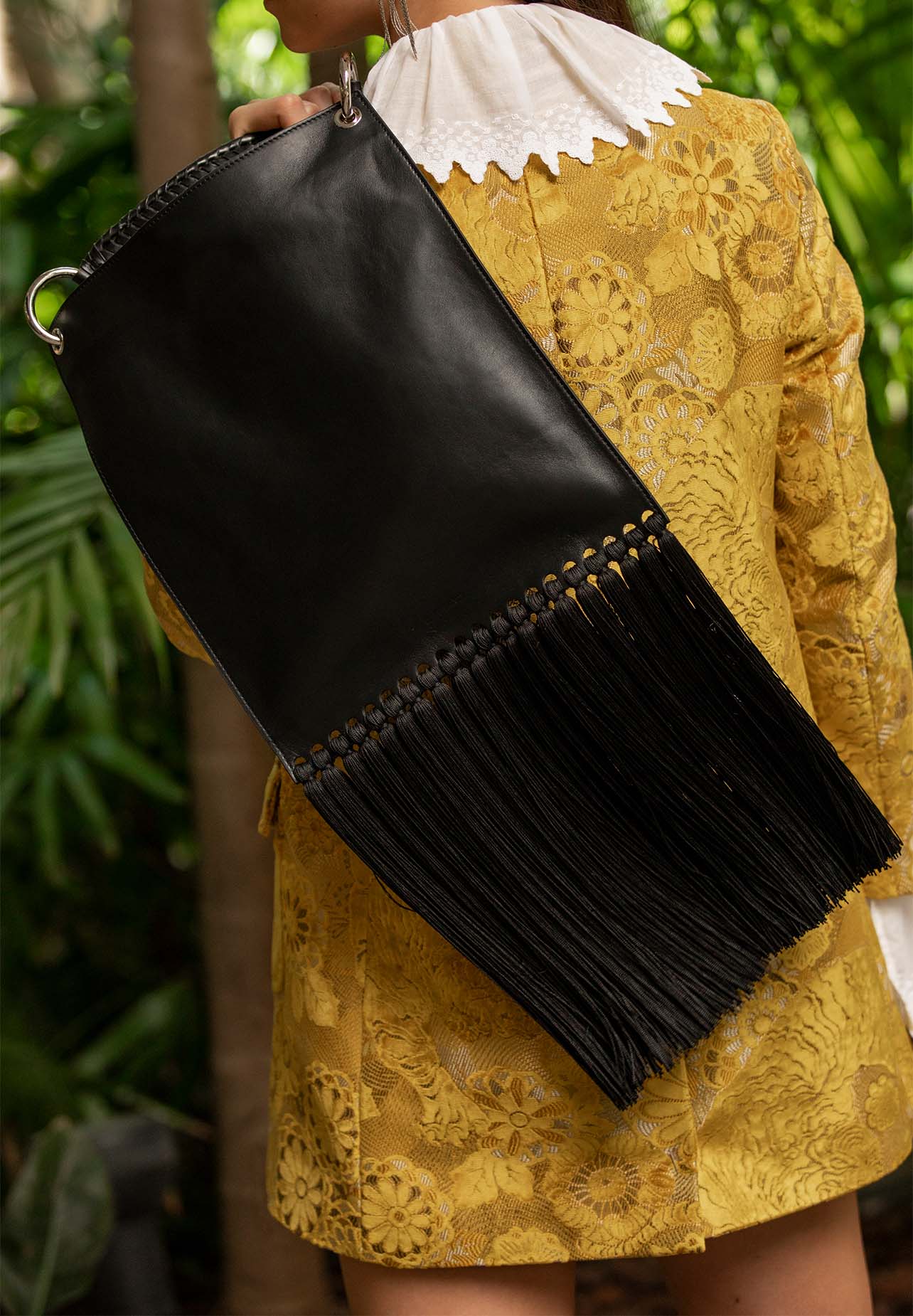 Close up shot of an Etro black leather bag with fringe detailing