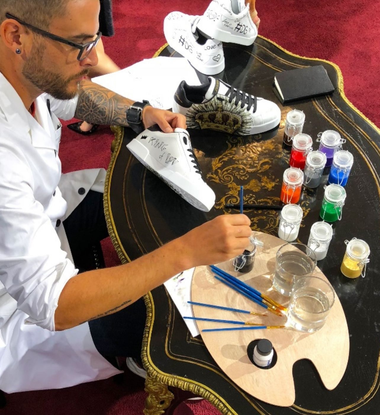 A man is painting a Dolce & Gabbana sneaker