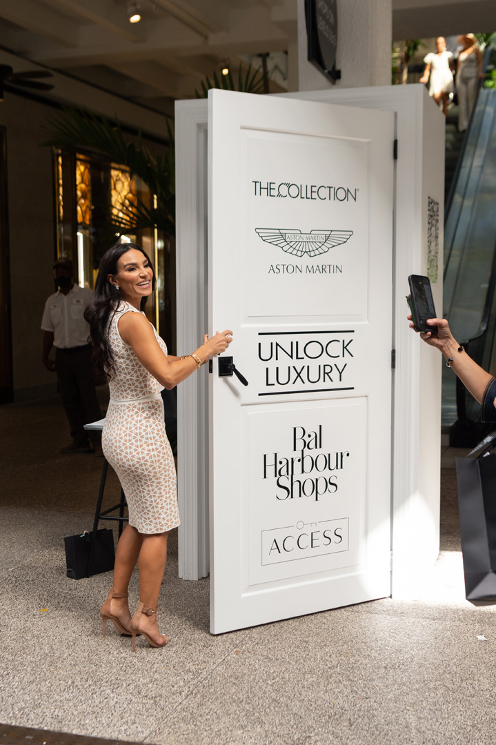 Alicia Peisteris smiles while opening a door in the Bal Harbour Shops courtyard