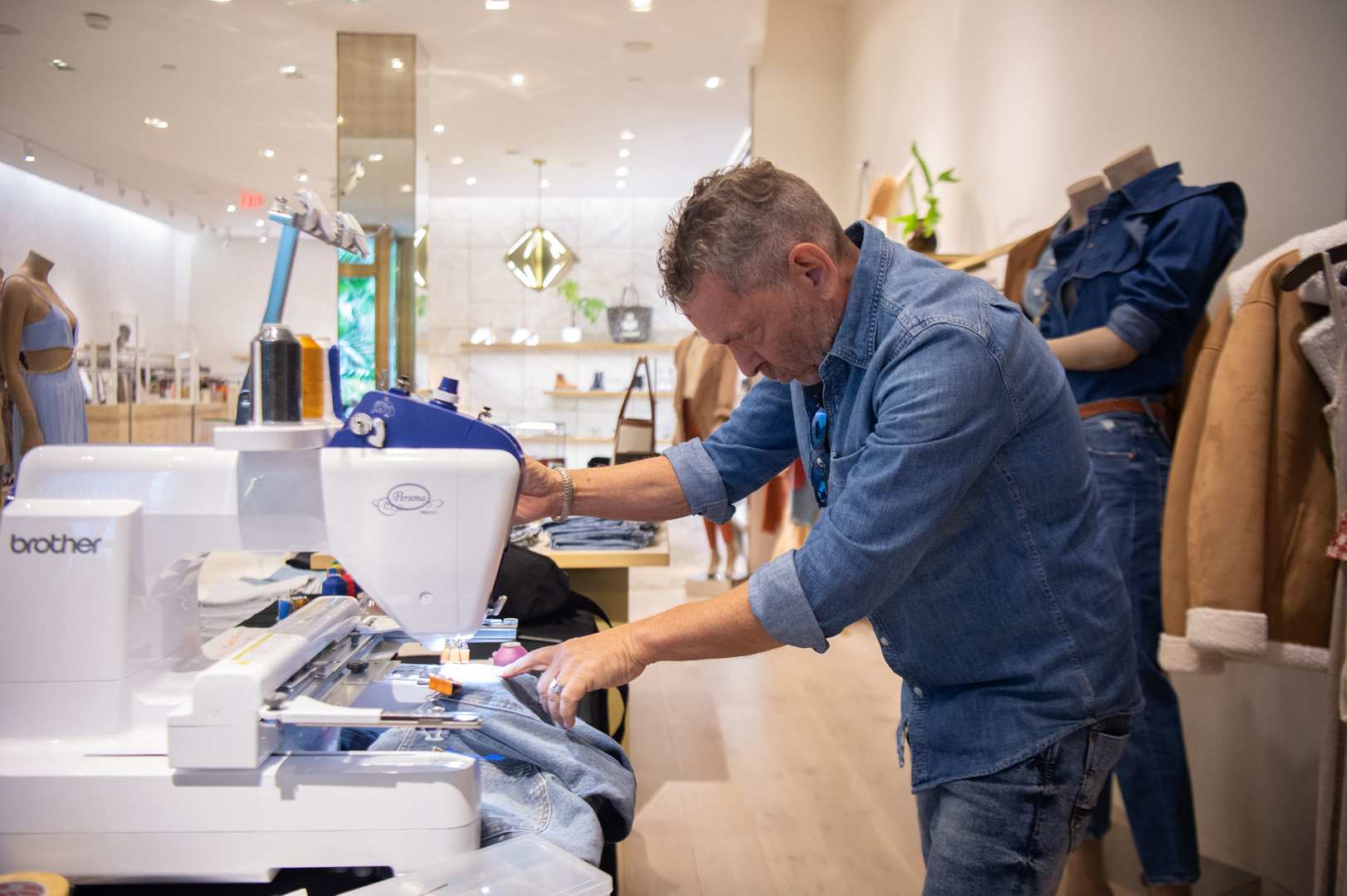 Craig Grossman embroidering jeans with a sewing machine