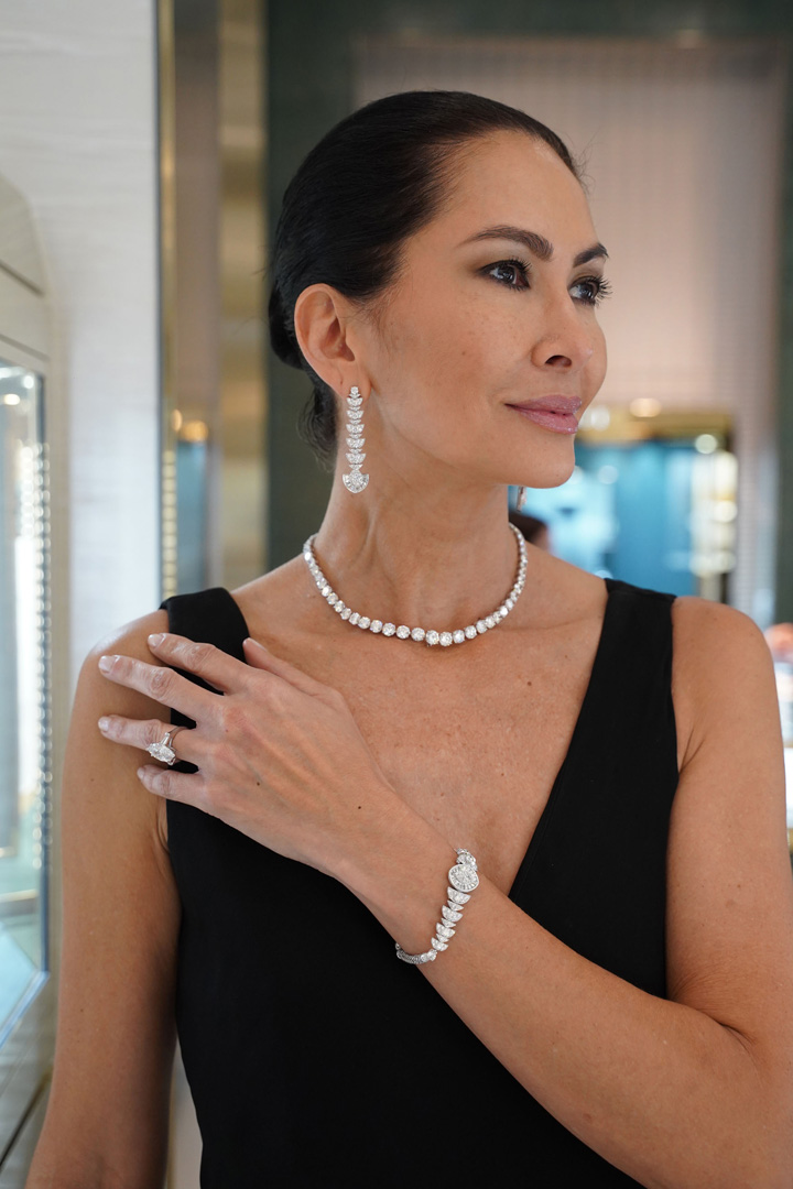Model poses wearing Graff diamond necklace, earrings, watch and ring