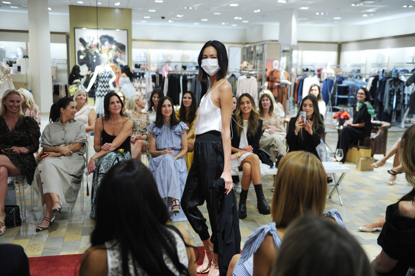 Model poses on runway as the crowd smiles