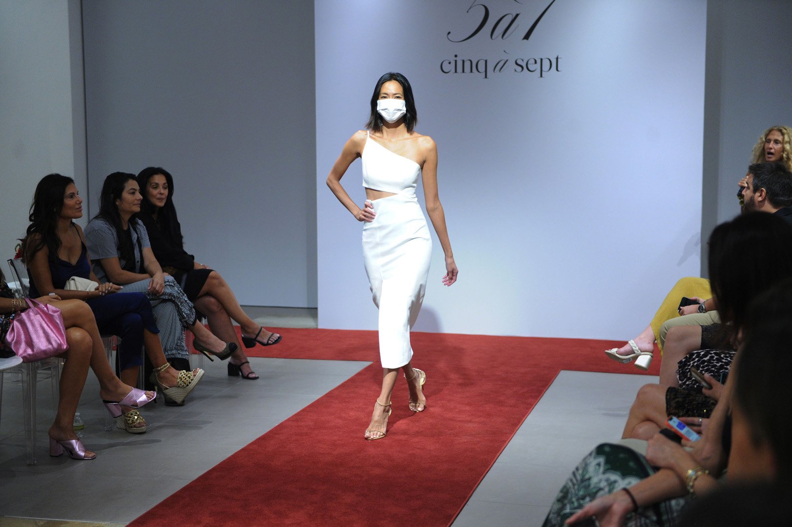 Model poses walking on runway in a white dress