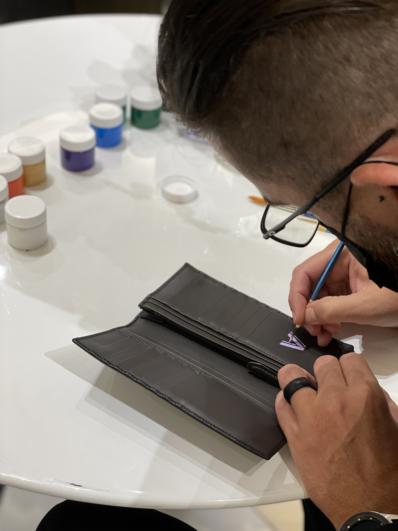 Man hand-painting a wallet