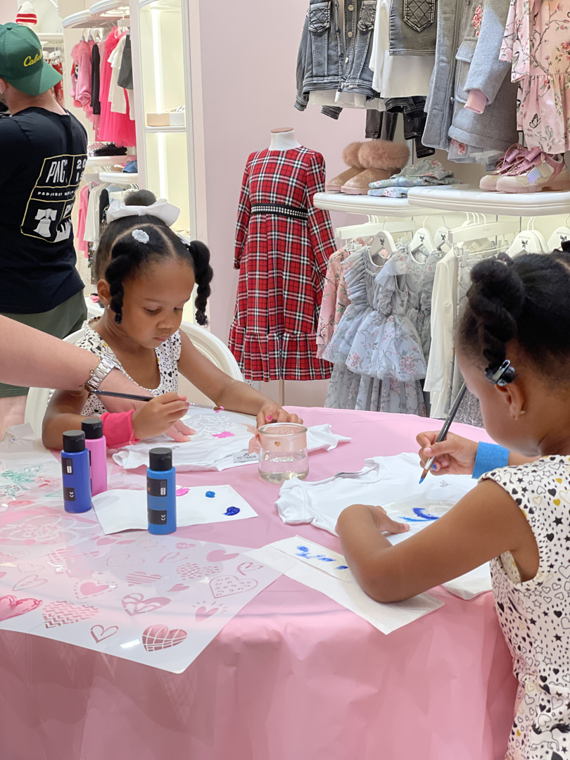 Two young girls painting t-shirts