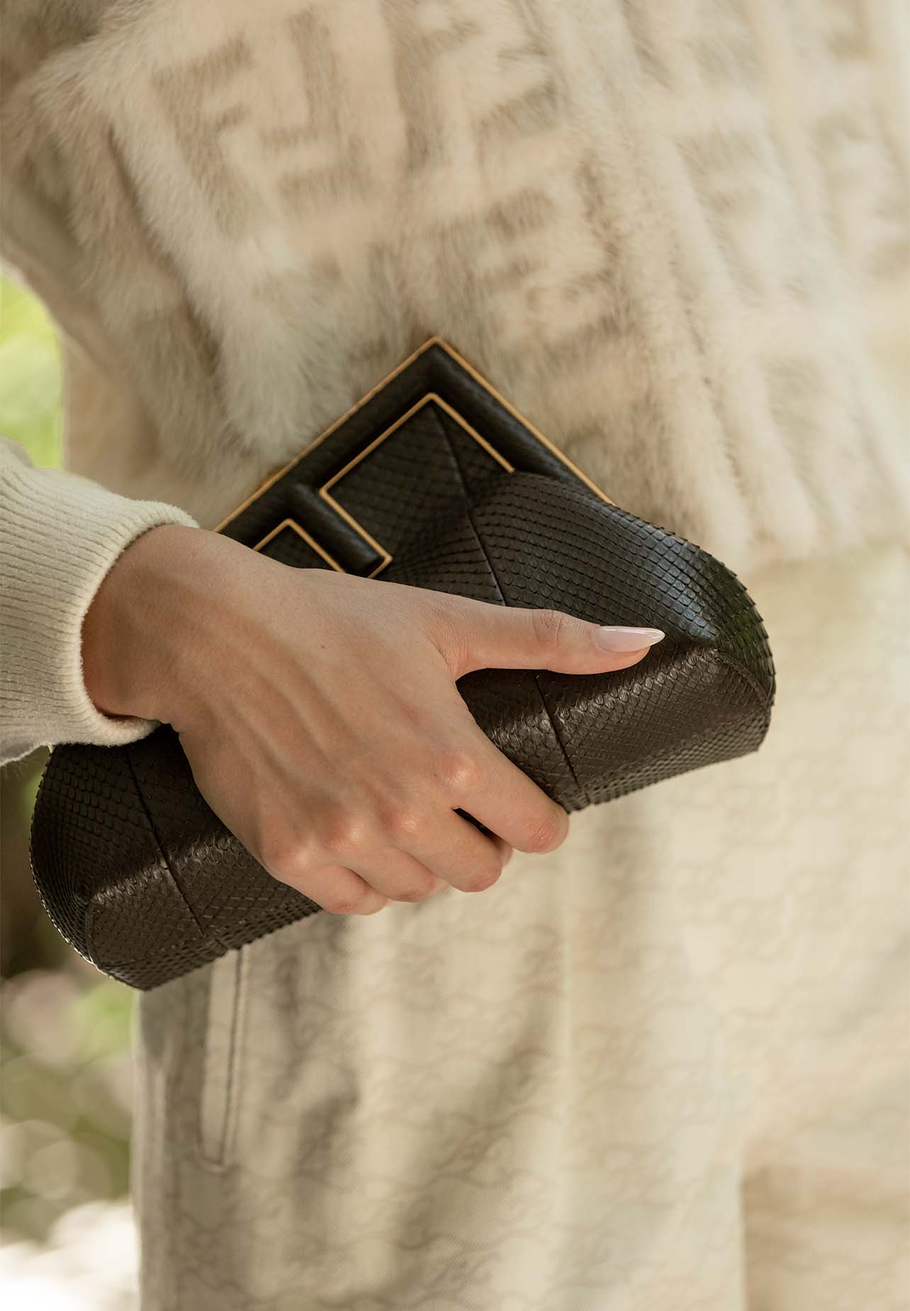 Close up shot of model holding a Fendi clutch
