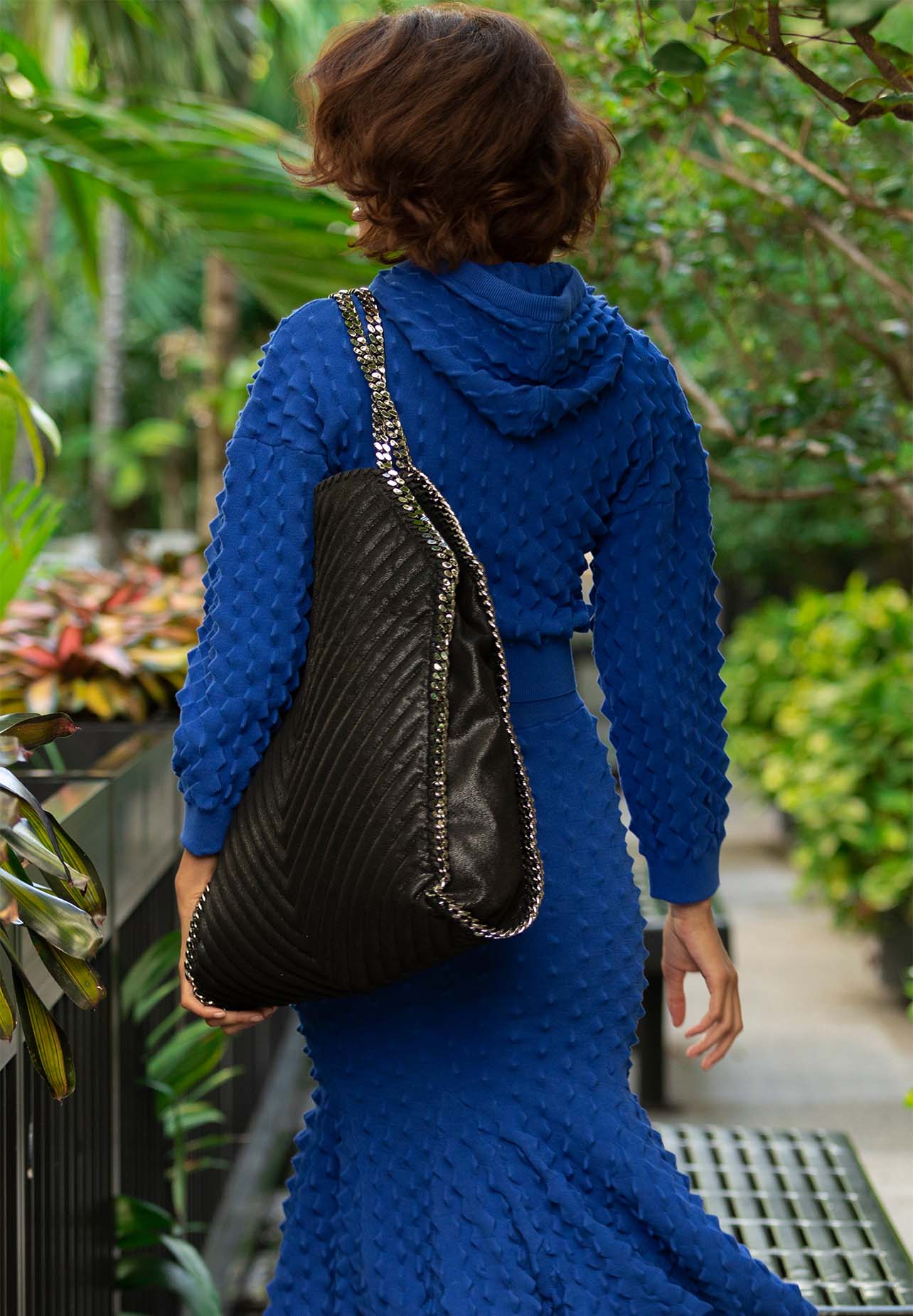 model smiles while walking in a full Stella McCartney blue look