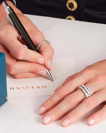 oman’s hand writing on a notepad with Bulgari branding
