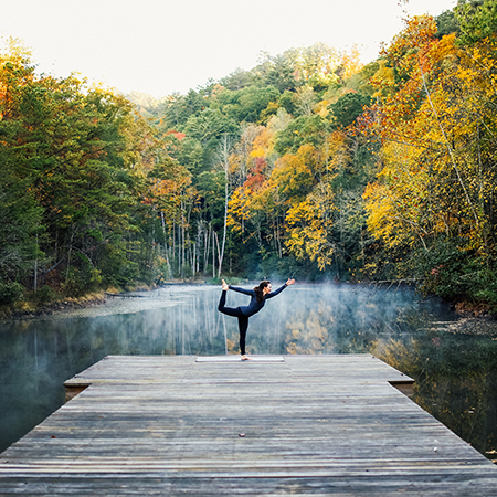 Woman holds a yoga pose on a dock