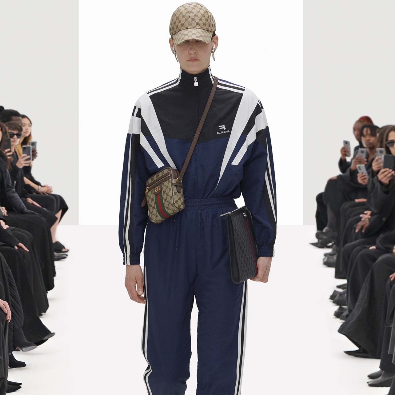 Model wears a Balenciaga navy jumpsuit with Gucci monogrammed accessories
