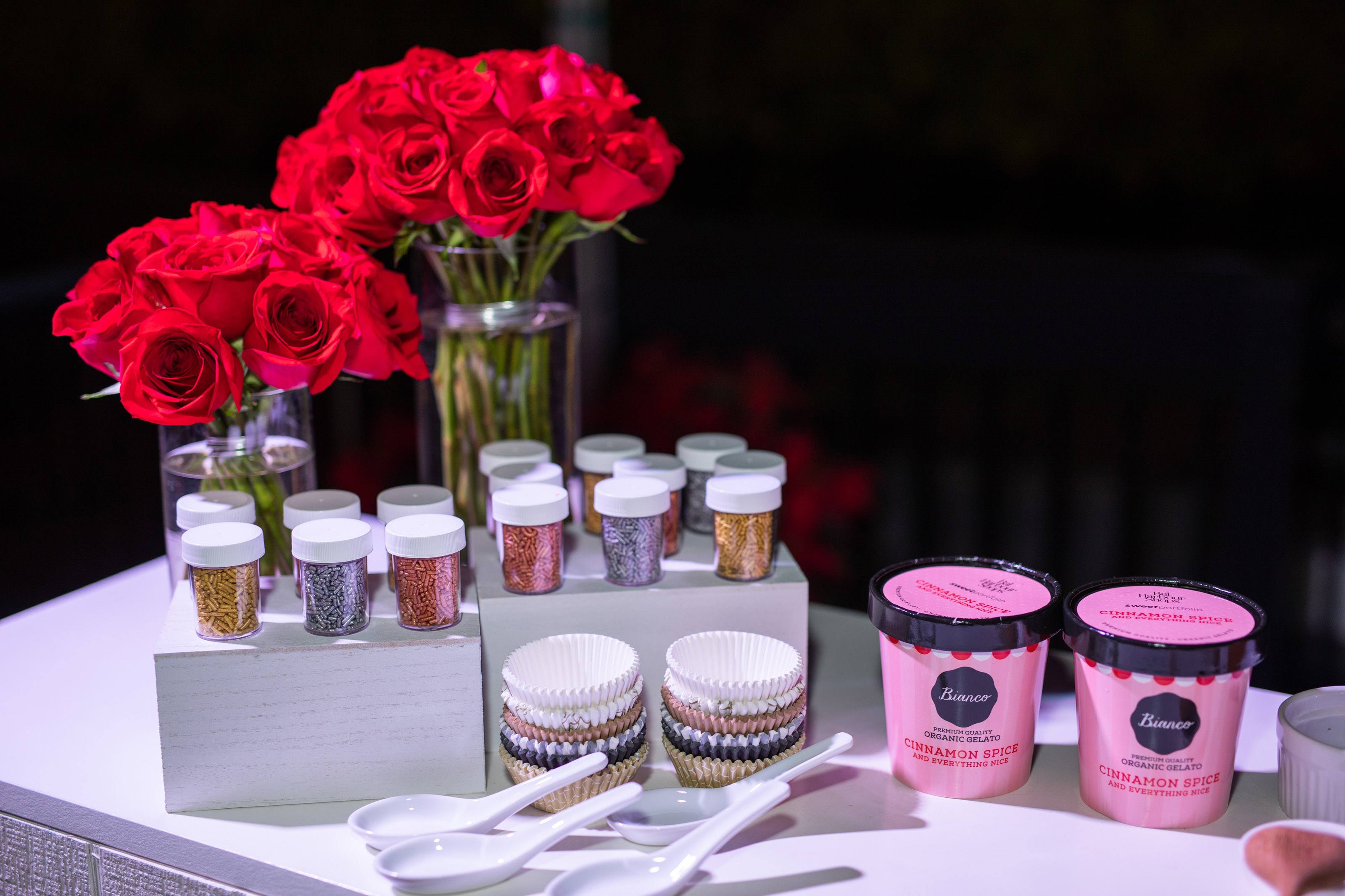 table set up with ice cream pints, sprinkles, spoons and various ice cream supplies