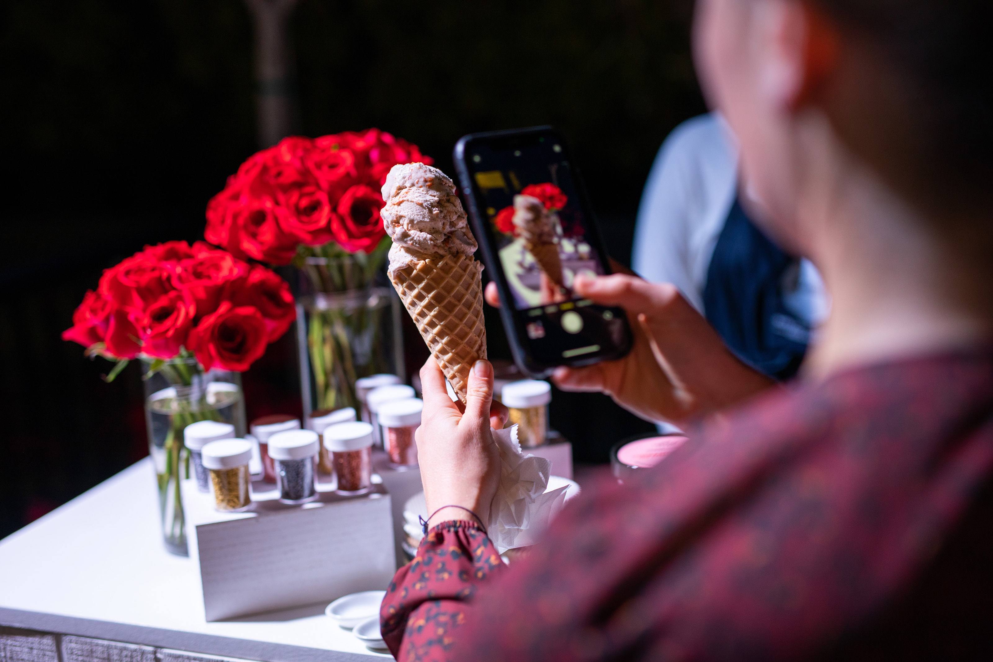 Woman snaps a shot of an ice cream cone on her phone