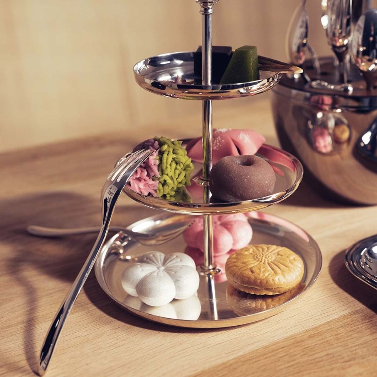 Silver plated fork resting on a silver tray of Asian inspired desserts