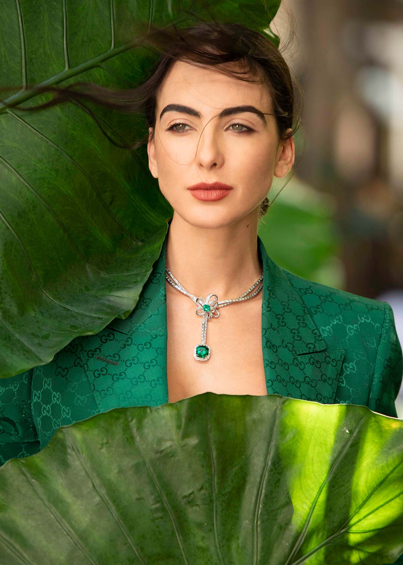 Close up shot of model wearing emerald colored diamonds
