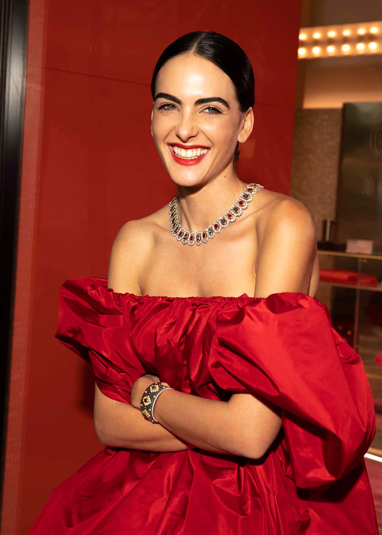 Close up shot of model smiling with a red lip and ruby high jewelry necklace
