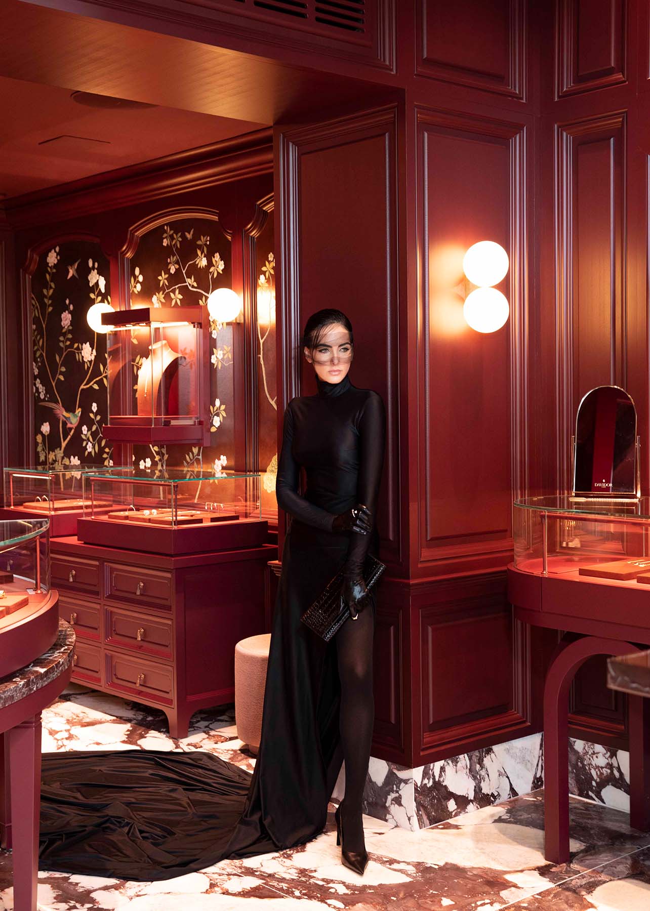 Model poses in the Davidor boutique in a full length long sleeve black gown
