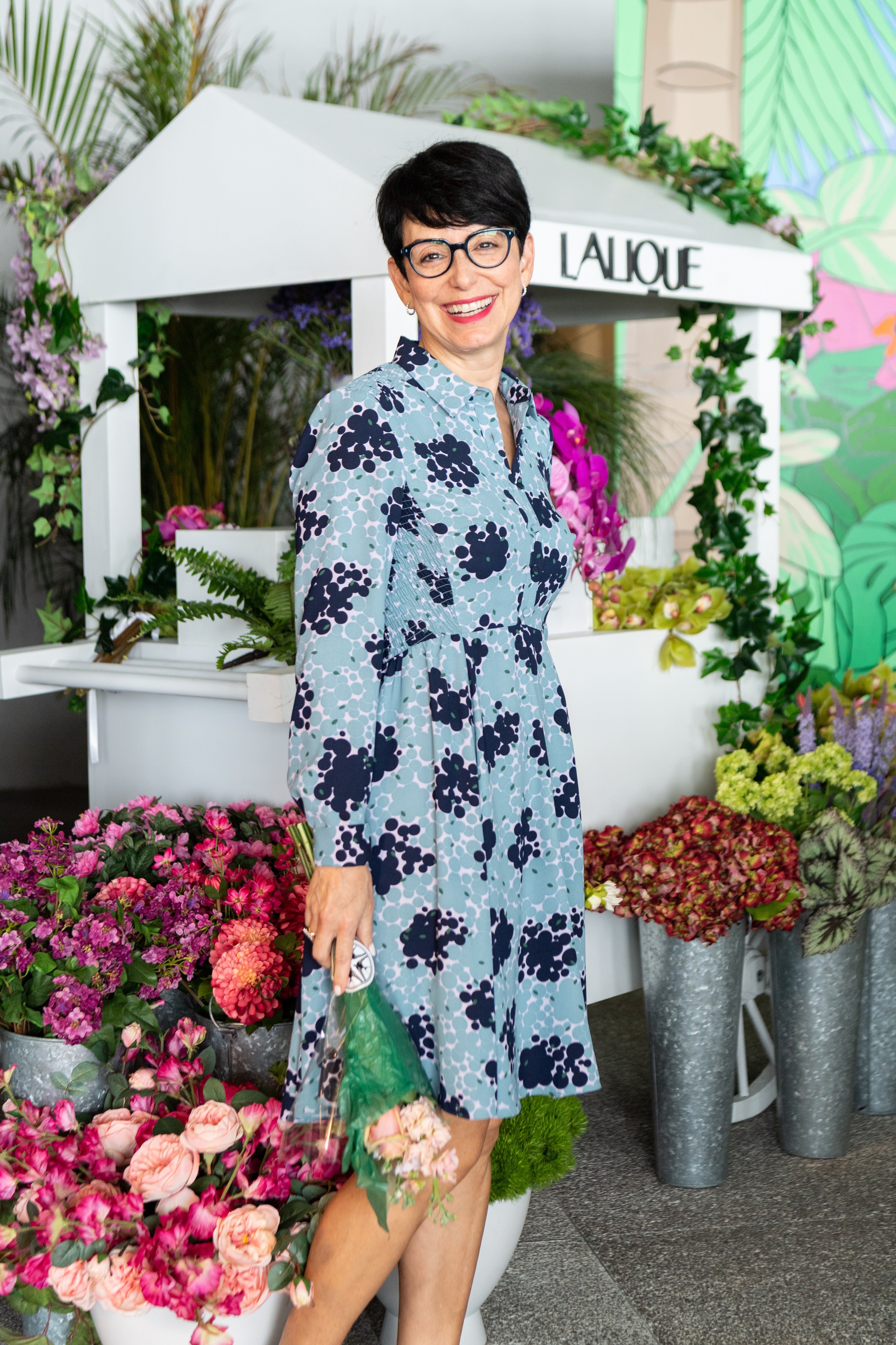 Woman smiles for a photo holding a bouquet of flowers