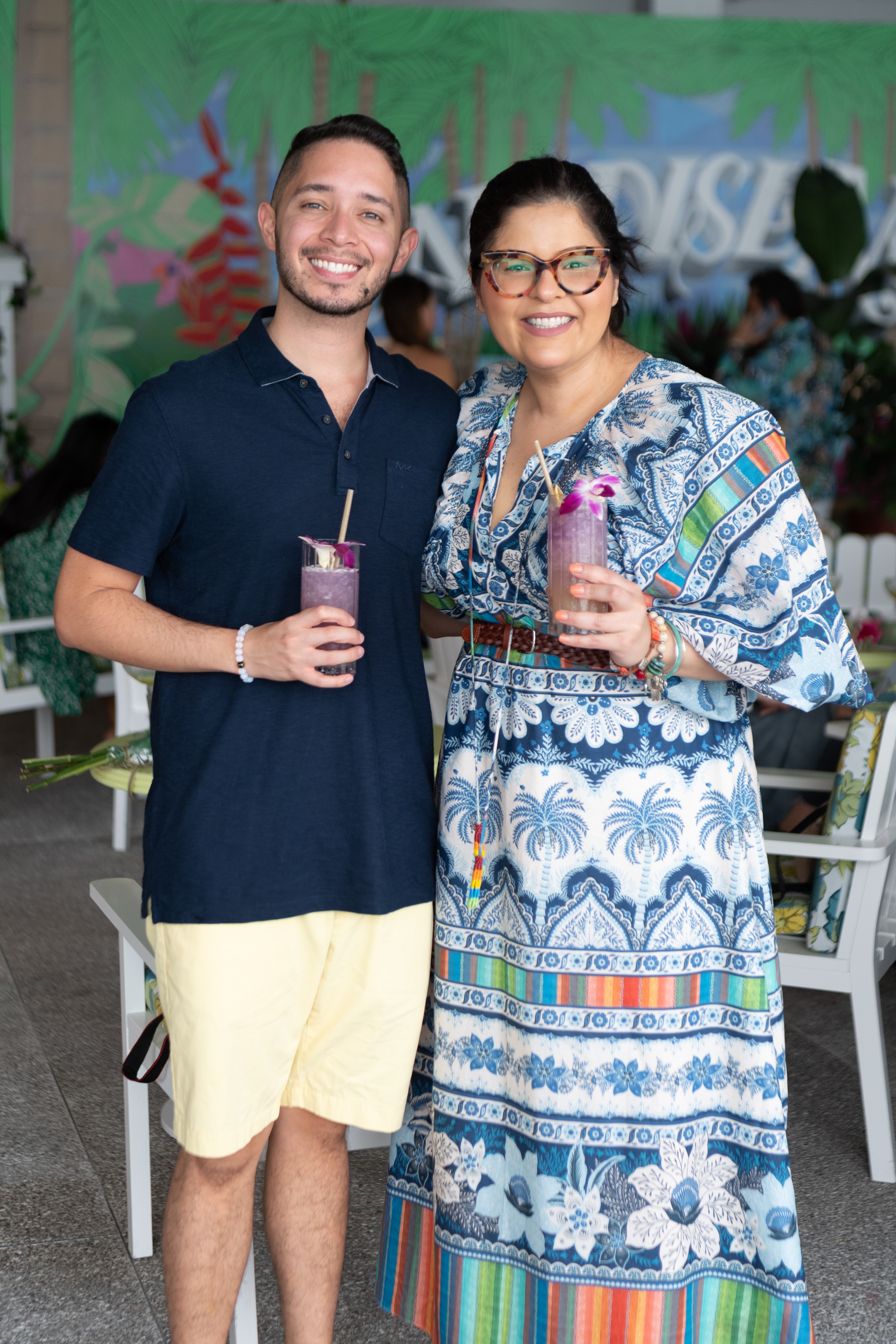 Man and woman smile for a photo together holding cocktails