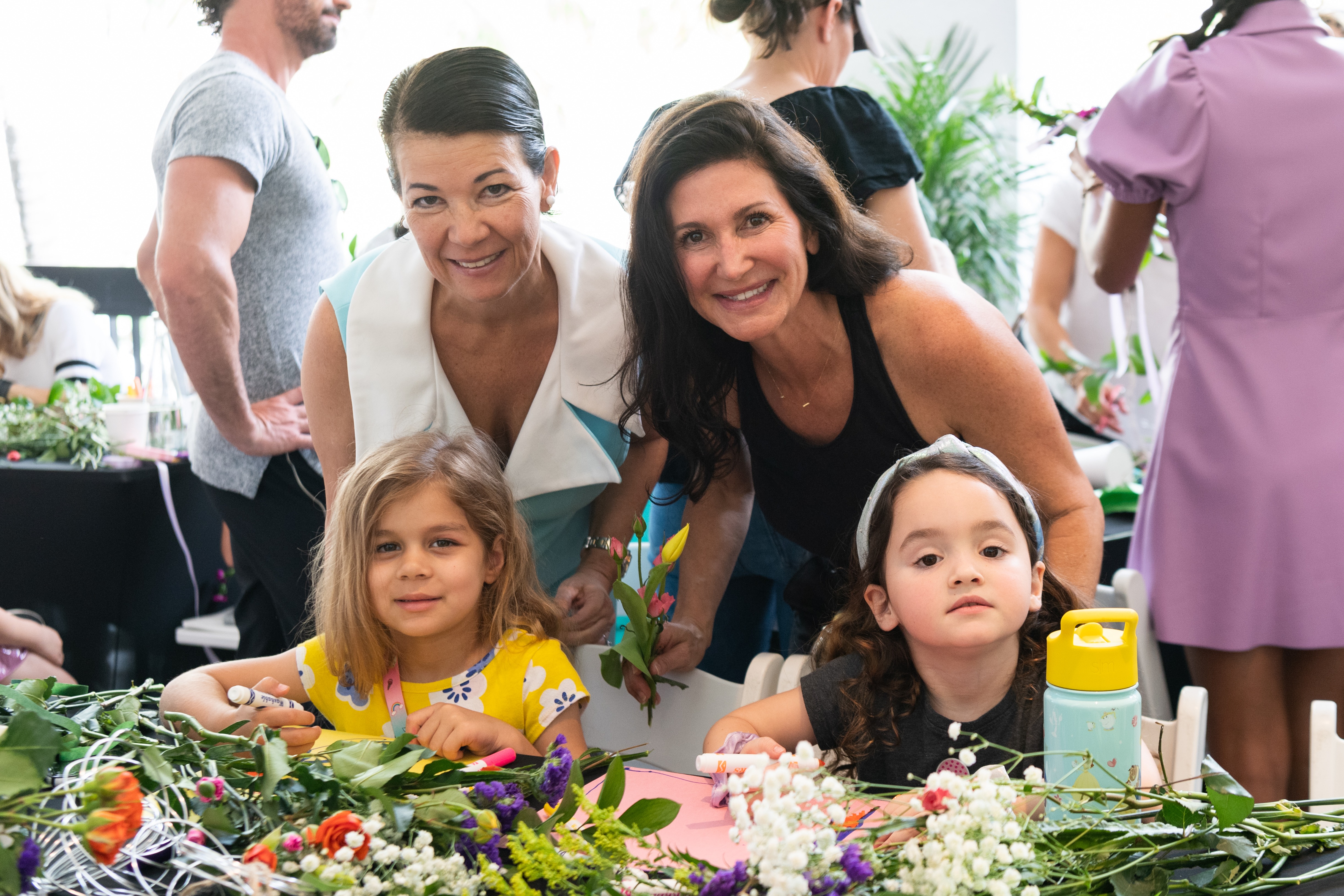 Two women smile with two young girls