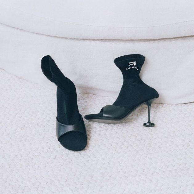 Black sock heeled booties with balenciaga written on the ankle