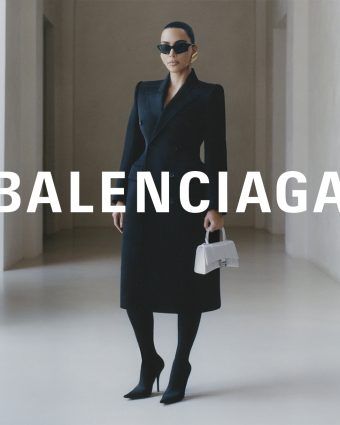Balenciaga campaign image featuring Kim Kardashian wearing a black suit set, black sunglasses and a white handbag