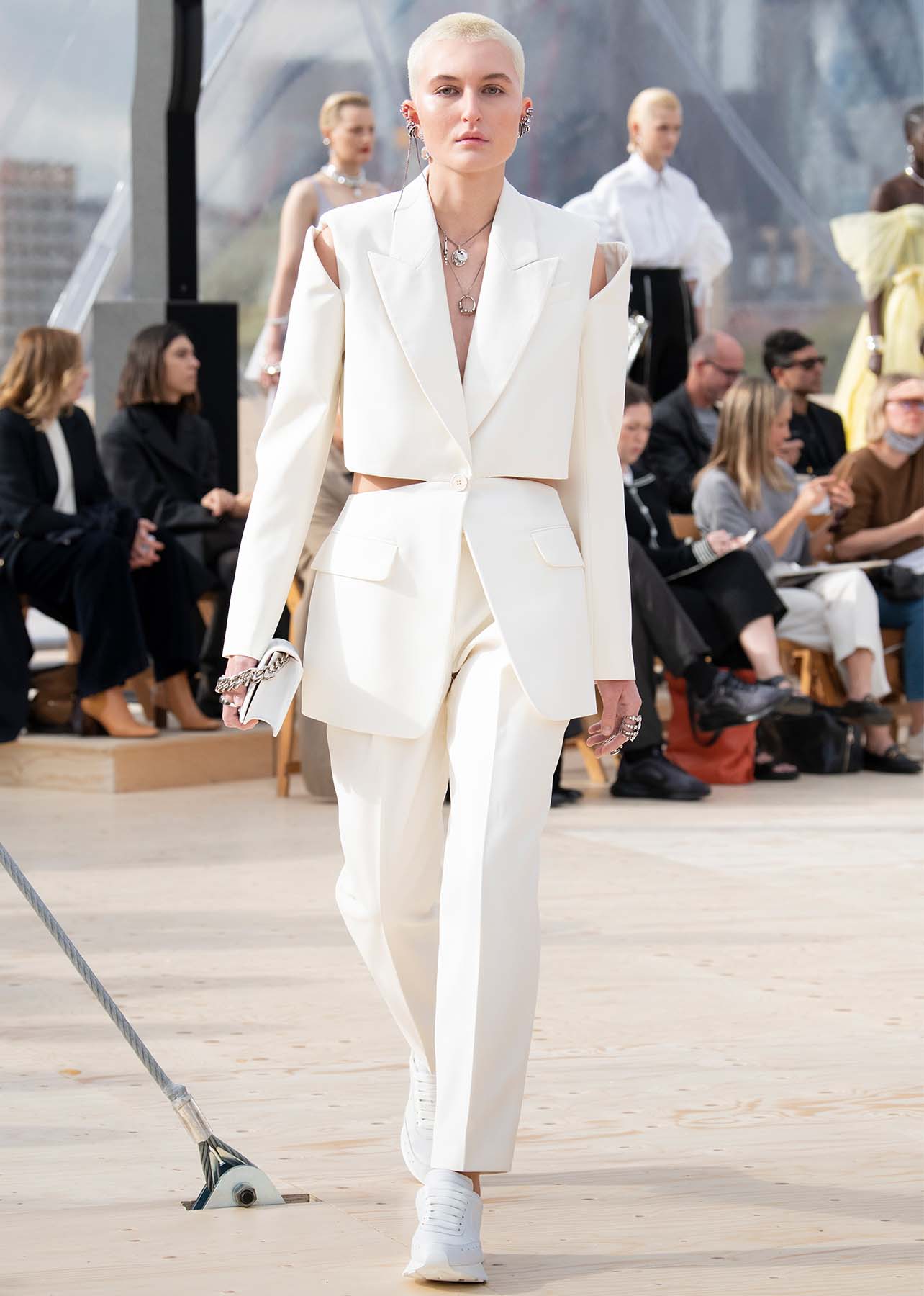 Model wears a white suit with cut outs