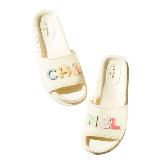 white chanel mules with rainbow chanel lettering across the toe