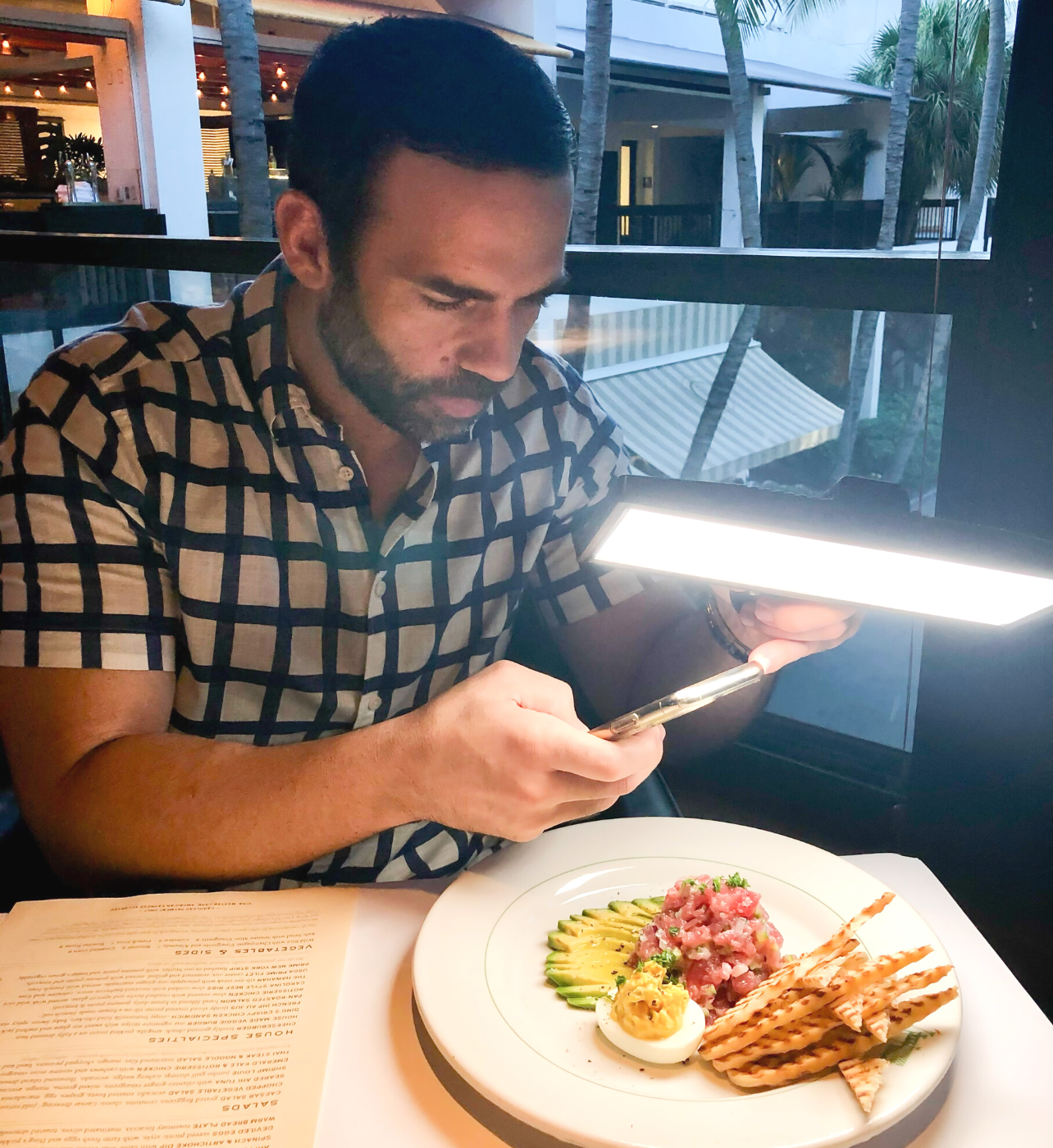 Yanni Georgoulakis photographed taking a picture of a dish at Hillstone