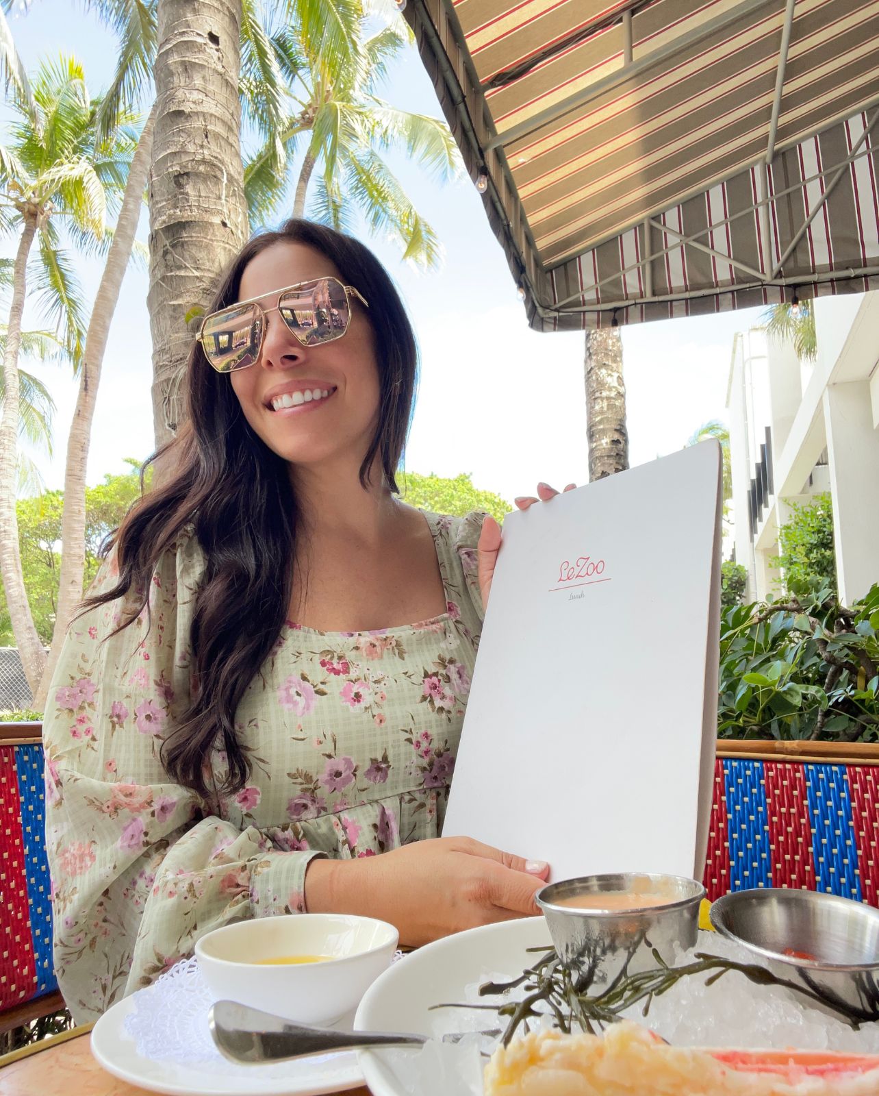 Woman smiles with a Le Zoo menu