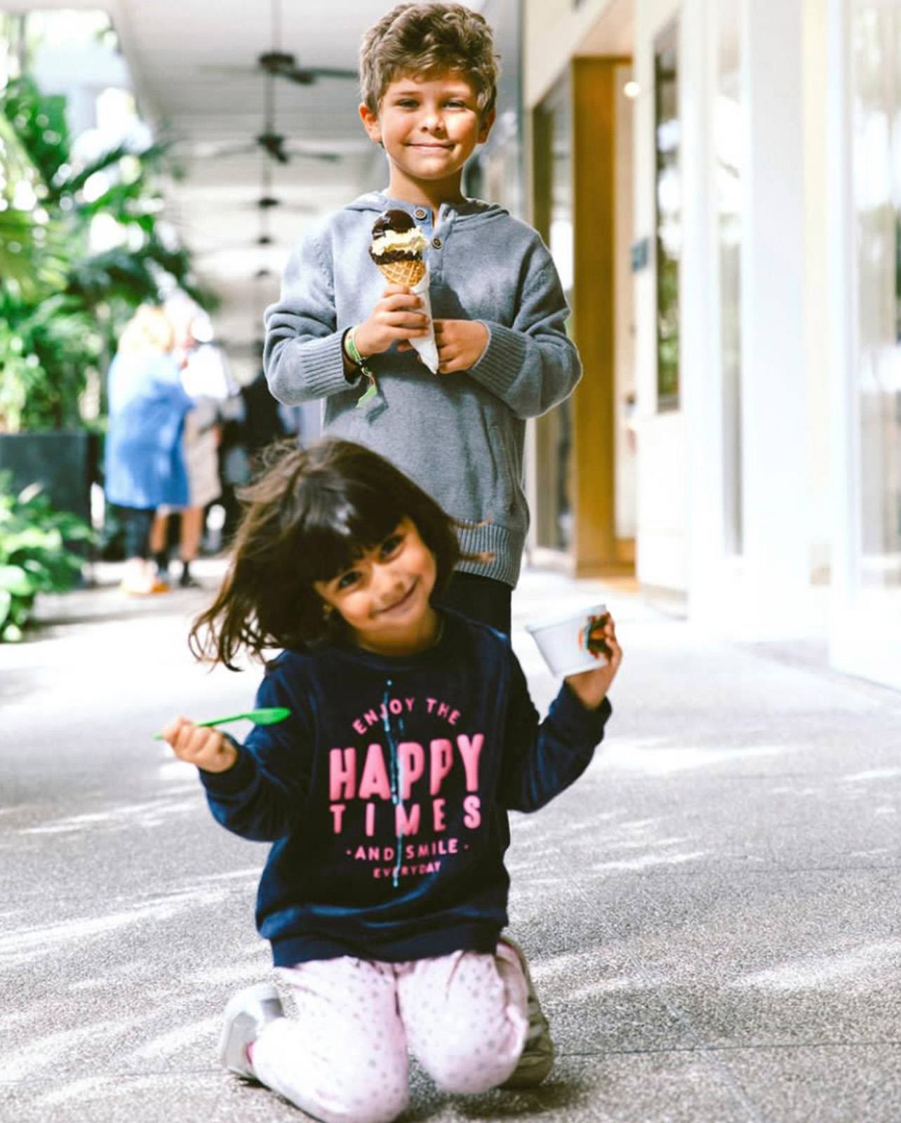 Two children smile with cups of ice cream